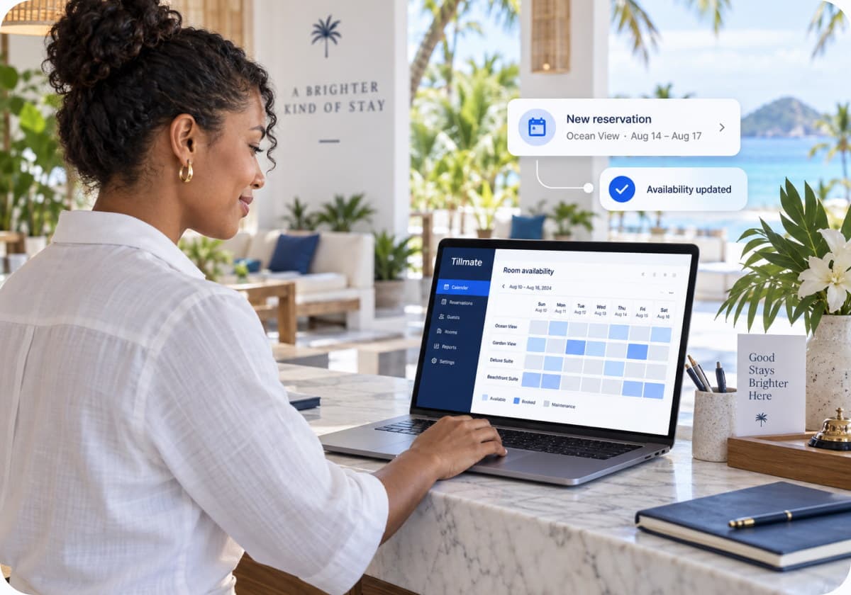 A hotel manager checking room availability on a laptop as a new reservation is confirmed